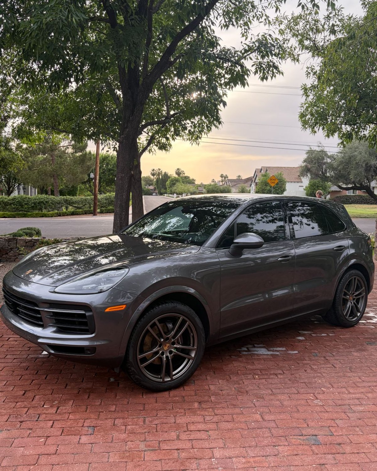 Grey Porsche Cayenne freshly detailed in the driveway